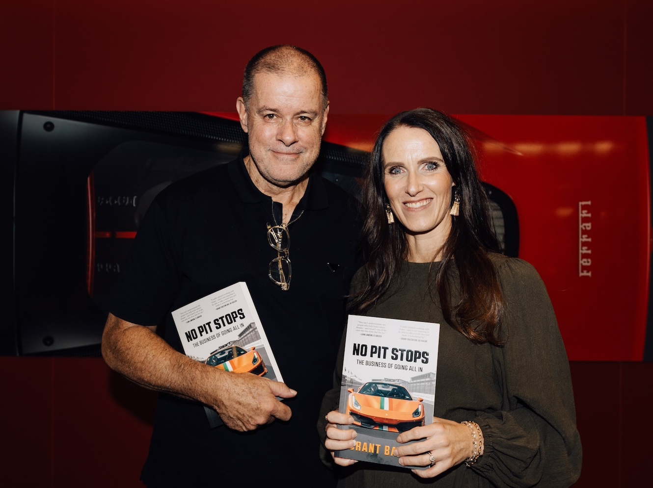 Ghostwriting client Grant Baker with ghostwriter Christina at Grant's book launch – both are smiling and holding copies of his book No Pit Stops